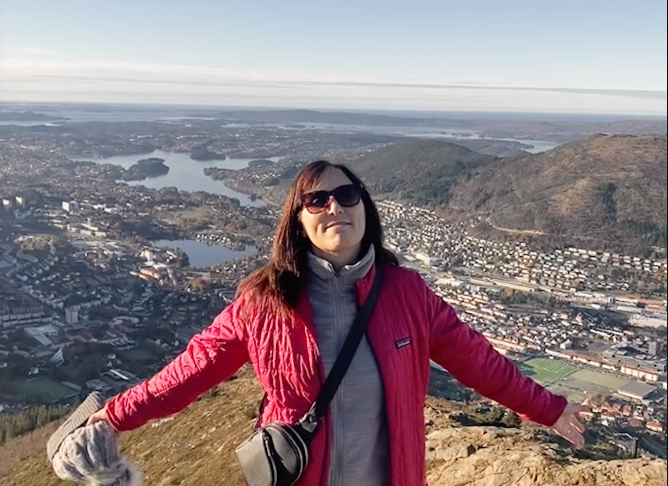 Erin Jacobs with her arms opened enjoying a mountain view in Bergen, Norway.