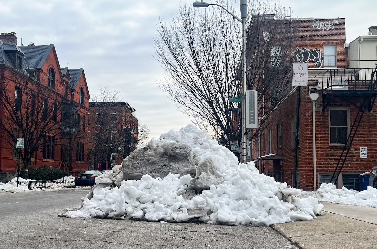 A large pile of snow partially blocks Eager Street near downtown Baltimore on Friday. (Ariel Zambelich/The Banner)

