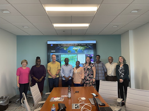 Group picture of team together in conference room in front of a screen