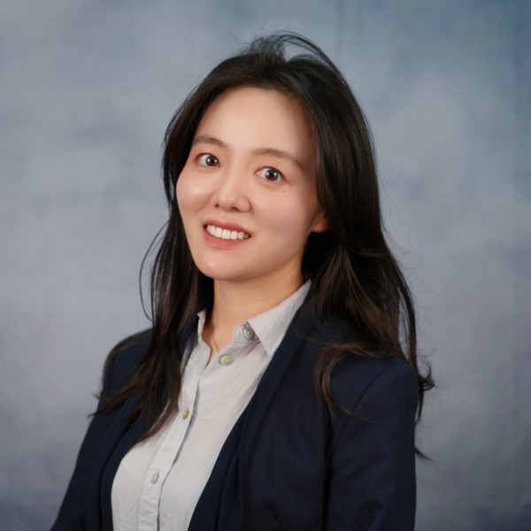 A woman dressed in a tailored business suit and tie, displaying professionalism in her appearance.