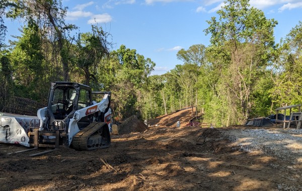 A construction site scene with a bulldozer and a tractor, highlighting ongoing earth-moving activities.