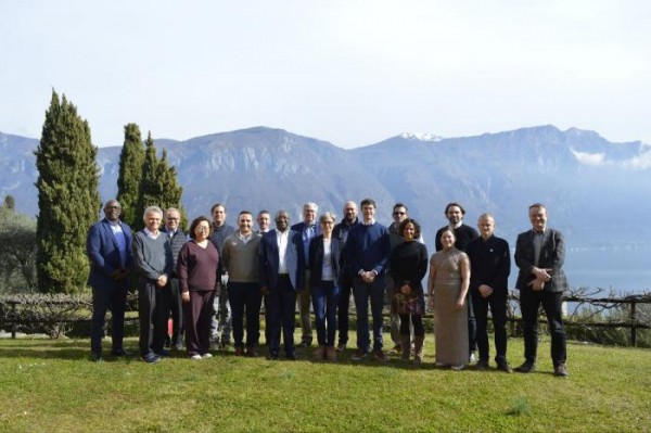A group of people pose for a photo against a mountain range.