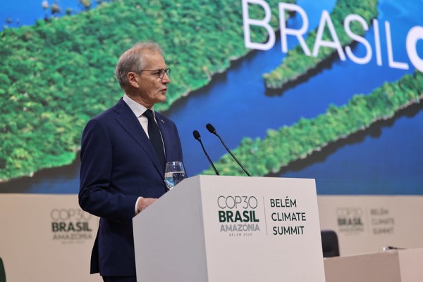 A man dressed formally in a dark suit speaks at a podium. 