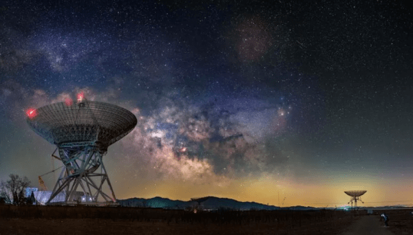 Two satellite antennas on the ground against the dusky sky 