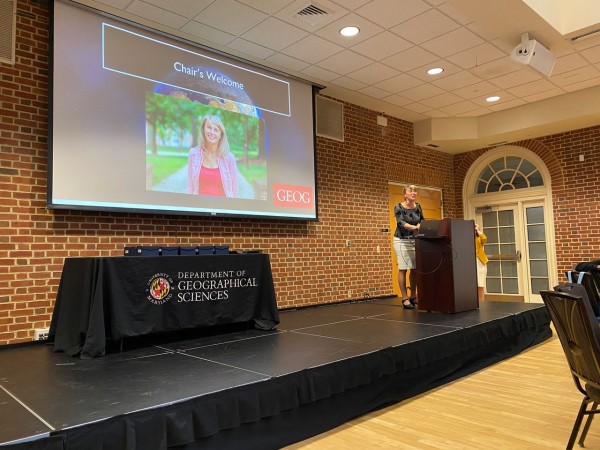 Tatiana Loboda stands at a podium and gives the welcoming address of the ceremony