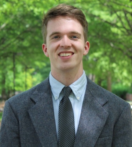 Munsell is a man smiling, wearing a suit and tie.