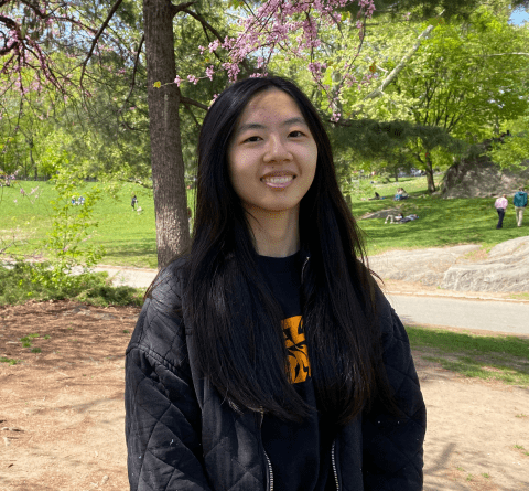 Photo of woman wearing black jacket standing in park