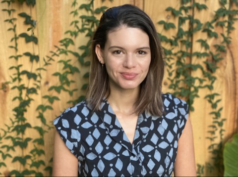 Photo of Ms Devereux against a backdrop with green vines