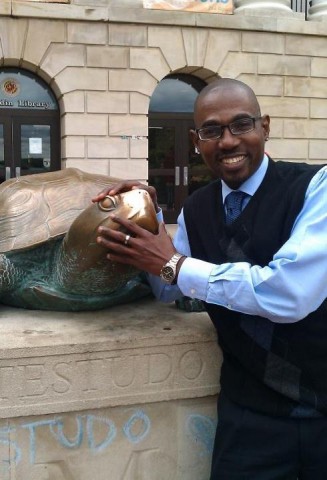 Keith Yearwood smiling with a Testudo statue 