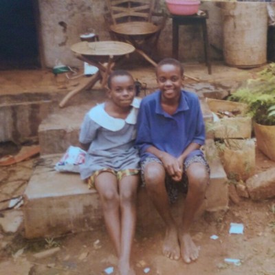 Catherine Nakalembe and her little sister Norah in front of their house