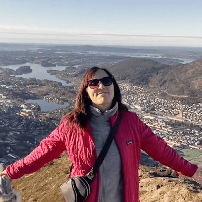 Erin Jacobs with her arms opened enjoying a mountain view in Bergen, Norway.