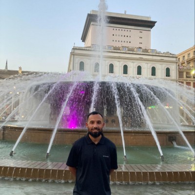 Byron stands in front of a fountain in Italy.