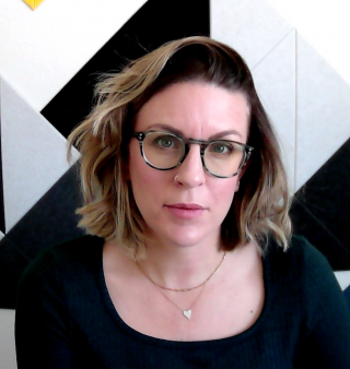 This is a photo of my face. I am wearing green glasses and I have chin length hair.